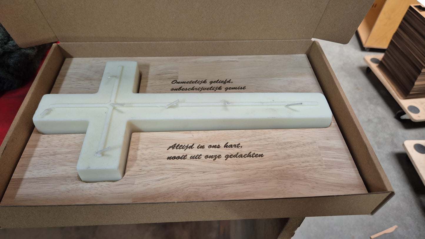Gedenkkaars in kruisvorm op houten plank