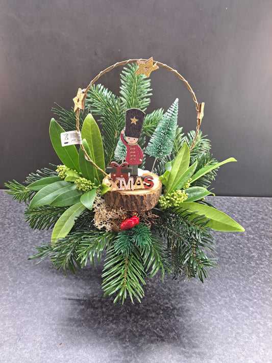 Kerststuk in zwart blikje met kerstgroen, houten poppetje en XMASboog met LEDlichtjes